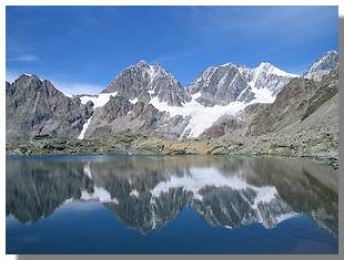 I pizzi Roseg, Scerscen e Bernina si specchiano nel laghetto delle Forbici. Foto di M. Dei Cas