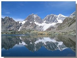 I pizzi Roseg, Scerscen e Bernina si specchiano nel laghetto delle Forbici. Foto di M. Dei Cas