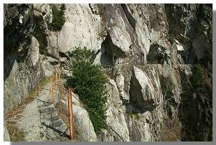 Il tracciolino si dipana fra impressionanti pareti granitiche. Foto di M. Dei Cas